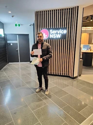 A new driver holding licence paperwork inside a Service NSW centre