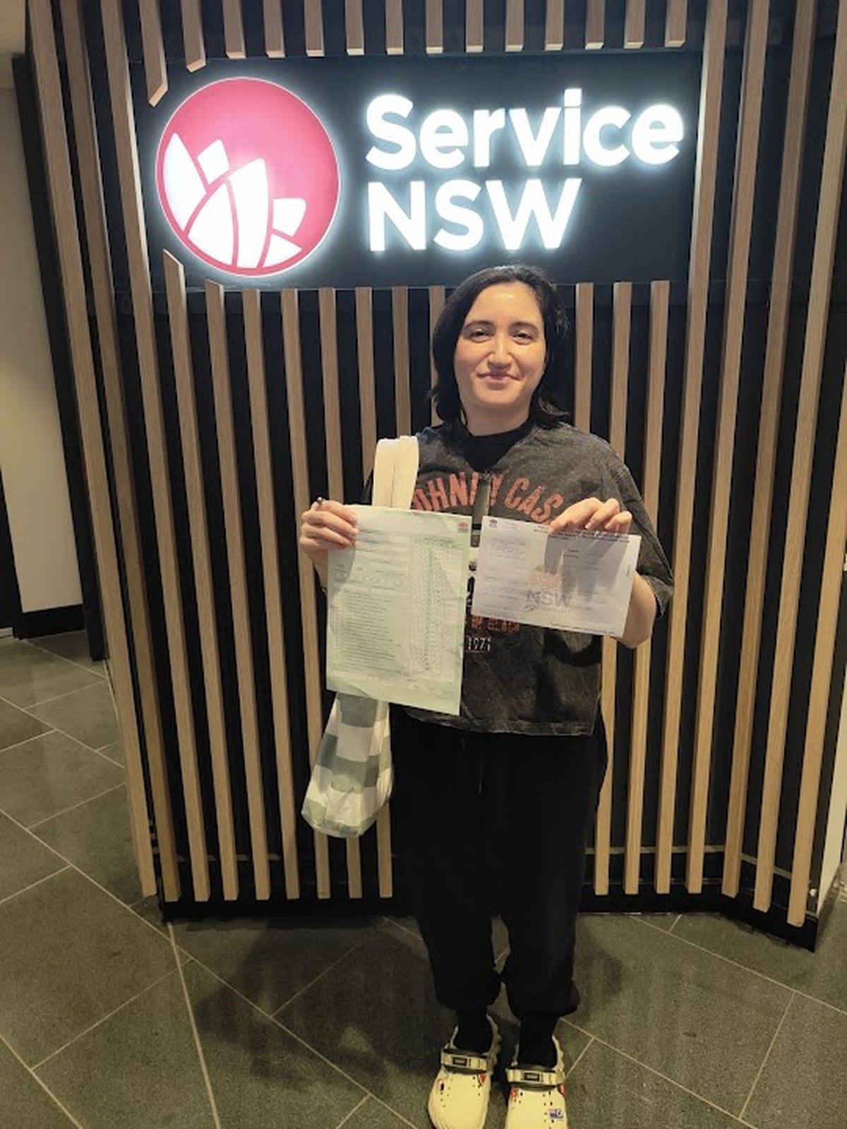 A new driver holding licence paperwork at a Service NSW centre